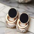 Zwart -gouden statementoorbellen met gelaagde geometrische bogen. Earrings by Tina