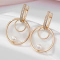 Oorringen met dubbele cirkelhanger en subtiel parelachtig accent. Earrings by Tina