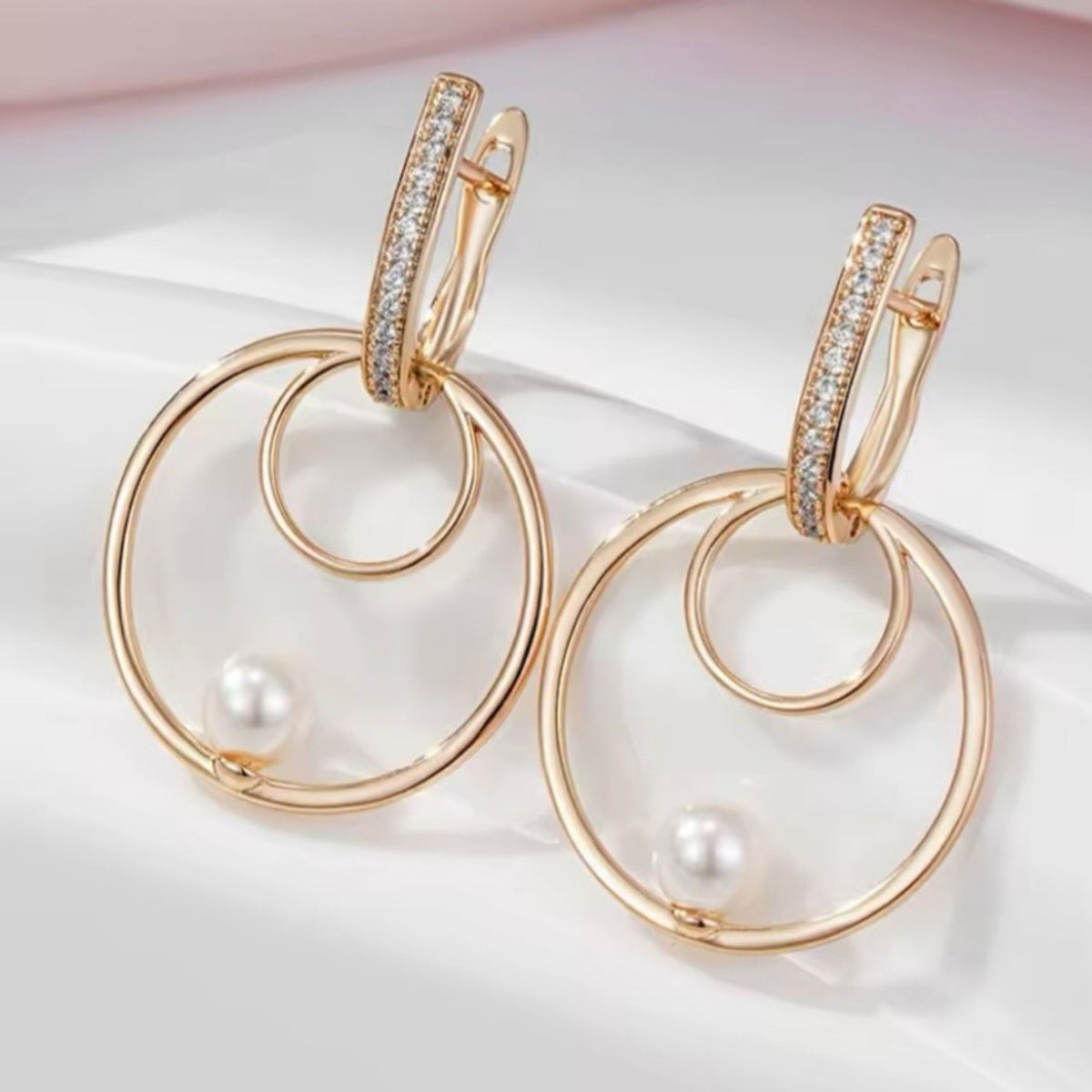 Oorringen met dubbele cirkelhanger en subtiel parelachtig accent. Earrings by Tina