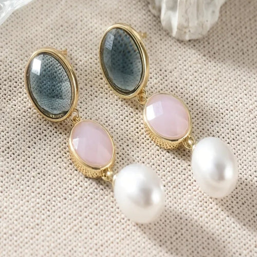 Blauw-roze hangende oorbellen met goudkleurige rand en parelachtige hanger. Earrings by Tina