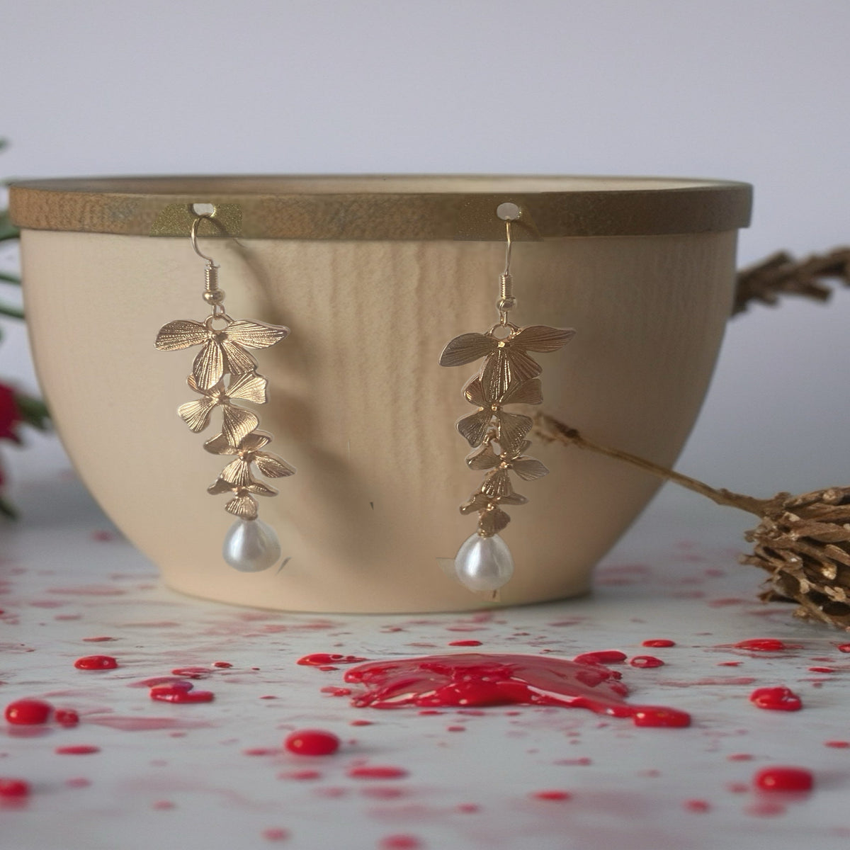 Hangende oorbellen met sierlijk bladmotief en parelachtige druppelhanger. Earrings by tina