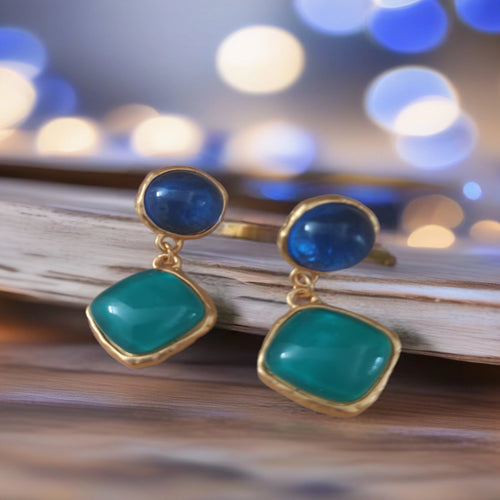 Blauw-turquoise hangende oorbellen met goudkleurige omlijsting. Earrings by Tina