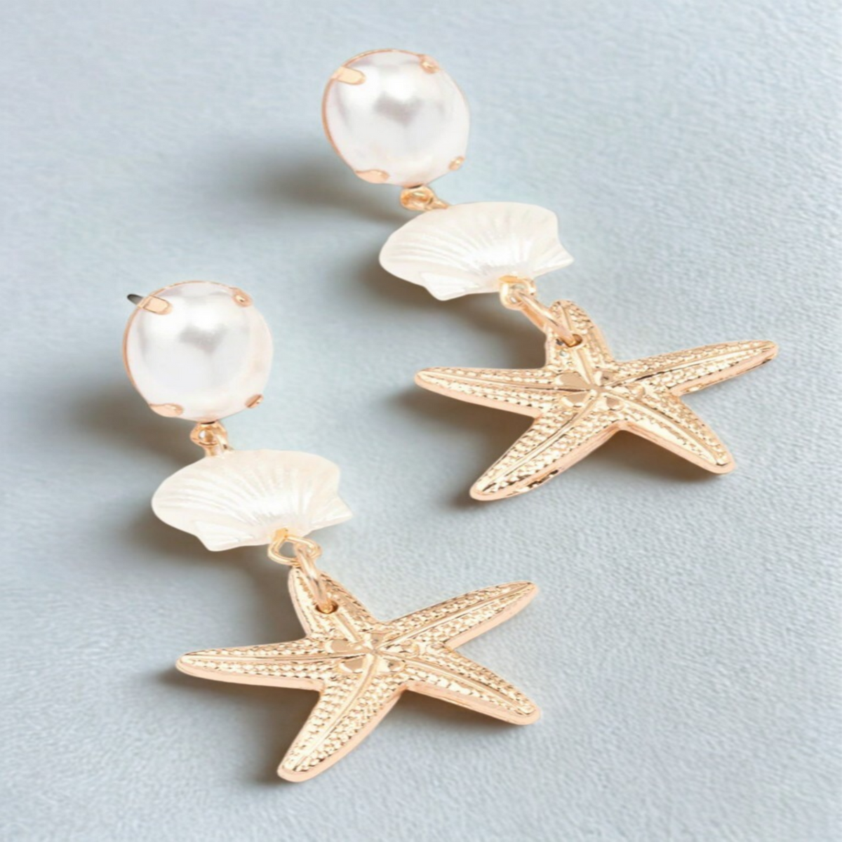 Zomerse zeester oorbel met schelp en witte parel. Earrings by Tina