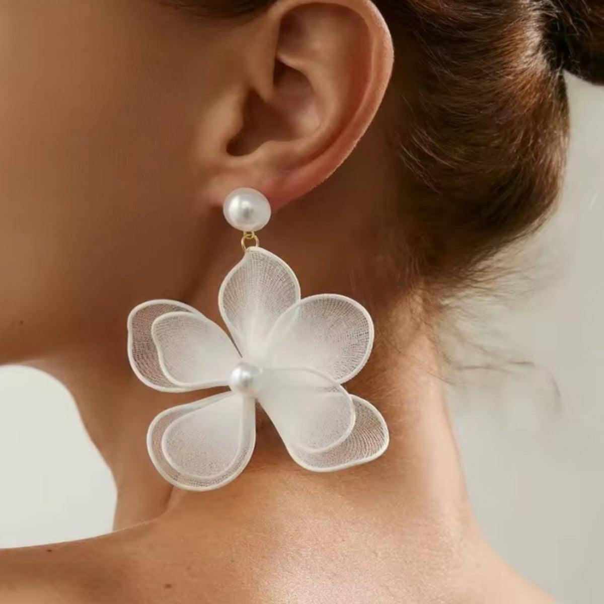 Grote witte bloemoorbel met parelachtige knop. Earrings by Tina