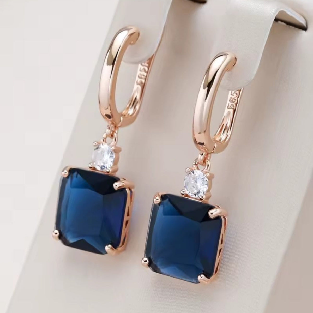 585 vergulde oorringen met vierkante diepblauwe steenhanger. Earrings by Tina
