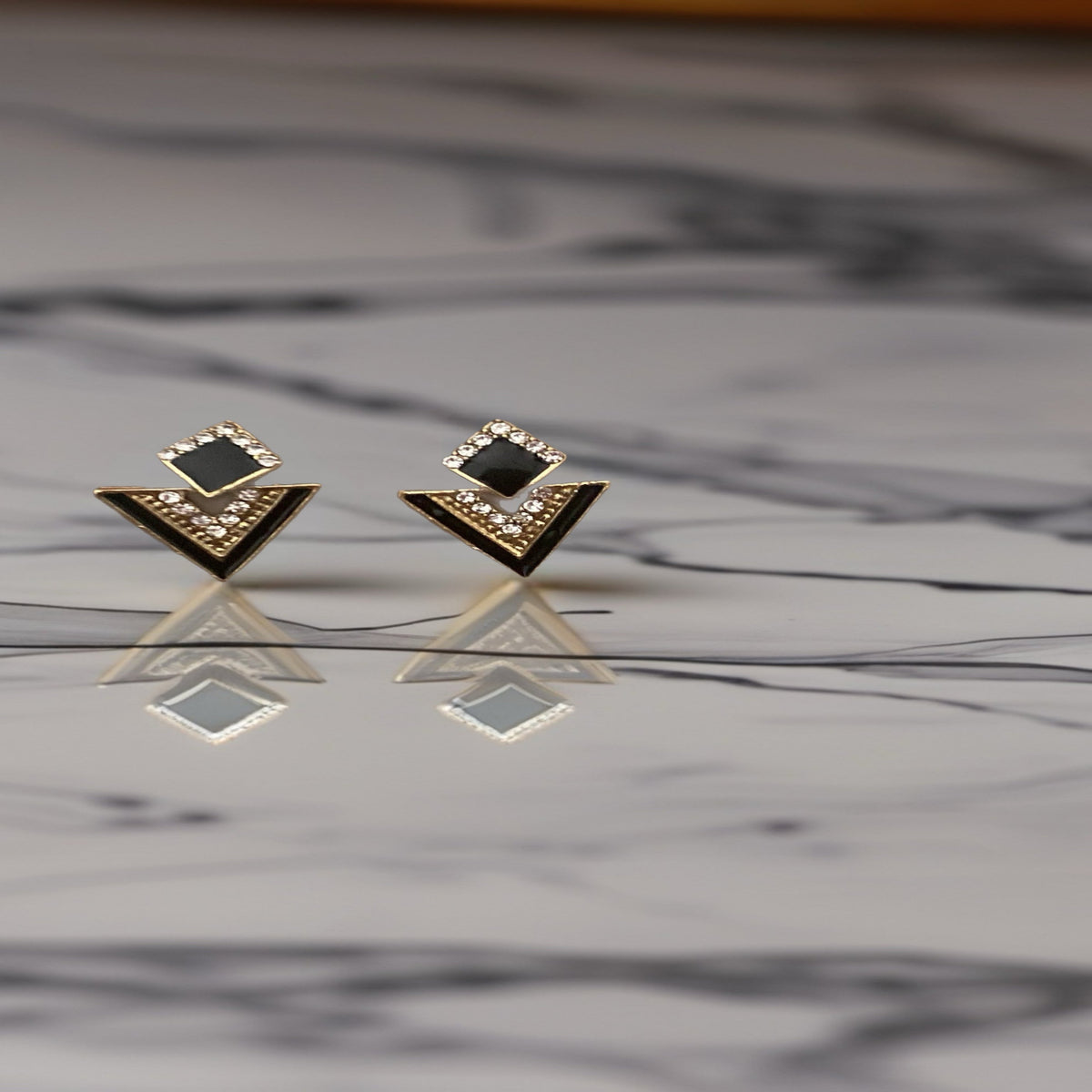 kleine goudkleurige V-oorstekers met vierkant fonkelende steentjes. Earrings by Tina