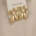Goudkleurige bloemoorbellen van roestvrij staal met gelaagde bloemblaadjes.Earrings by Tina