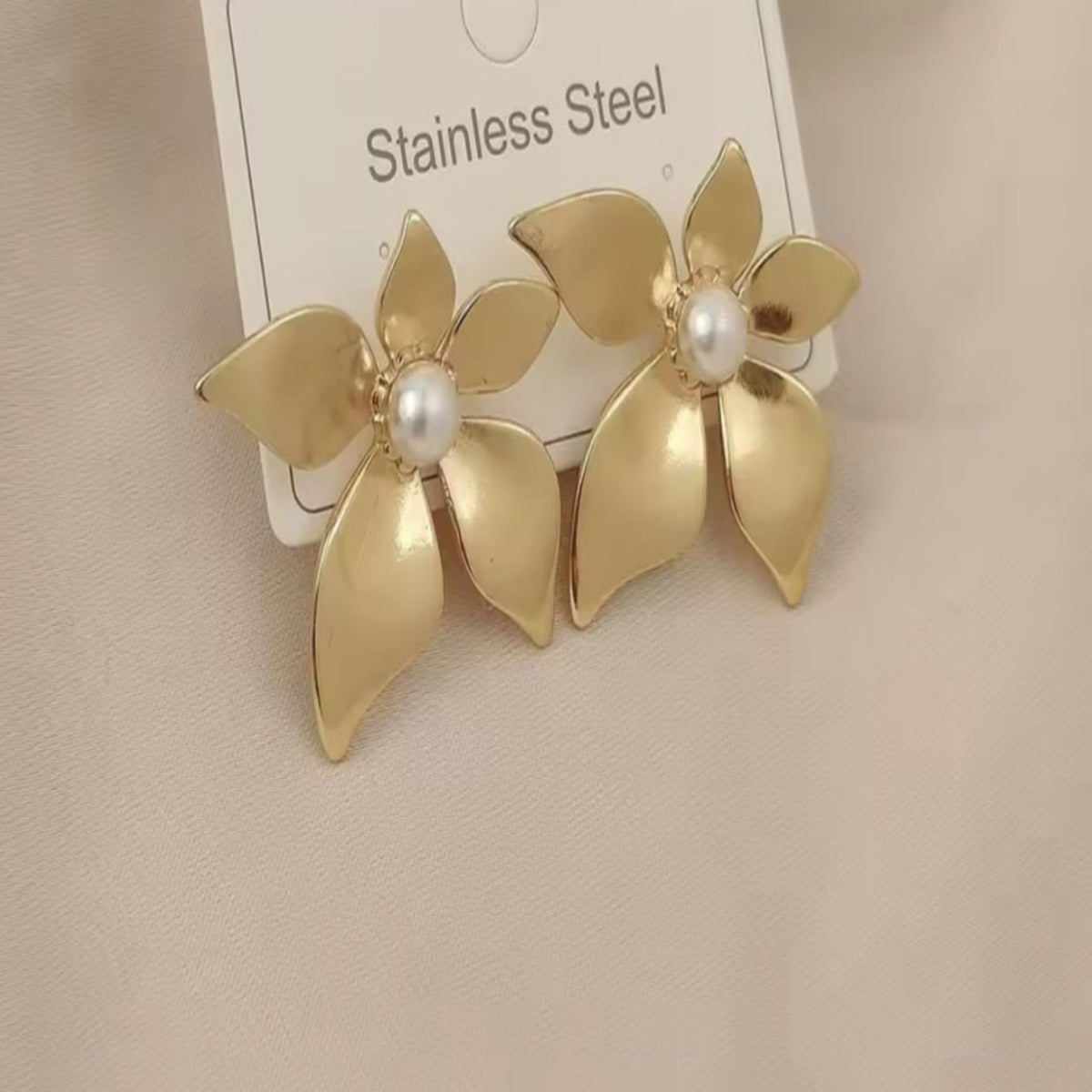 Goudkleurige bloemoorbellen van roestvrij staal met gelaagde bloemblaadjes.Earrings by Tina