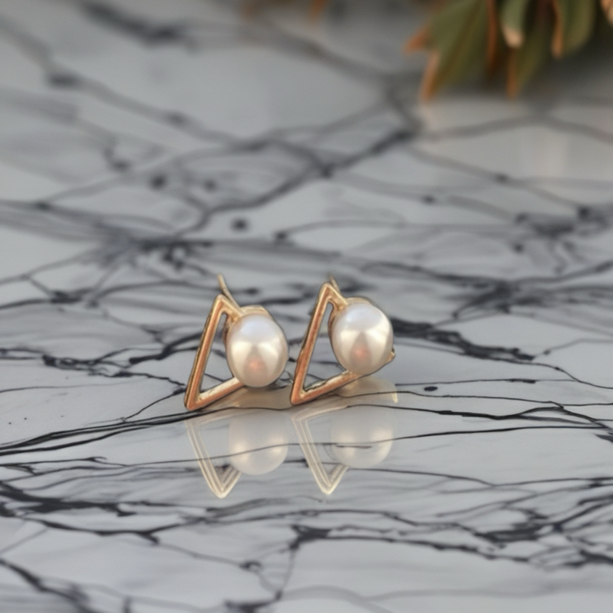 Parelstekers met goudkleurig geometrisch driehoekdetail.Earrings by  Tina