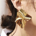 Grote Goudkleurige statementoorbel met abstract gelooid ontwerp.Earrings by Tina 
