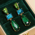 Groen-blauwe statementoorbellen met grote gefacetteerde steentjes. Earrings by Tina