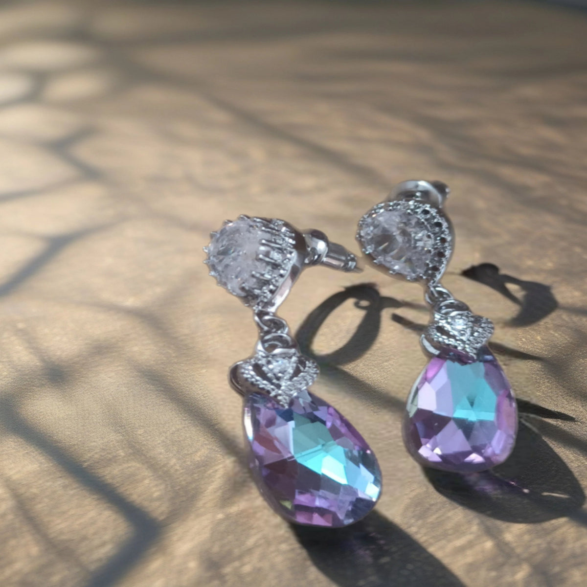 Zilverkleurige druppeloorbellen met grote transparante ene fonkelende steentjes. Earrings by Tina