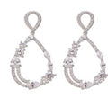 Zilverkleurige open druppeloorbellen van 4 cm met fonkelende detail. Earrings by Tina